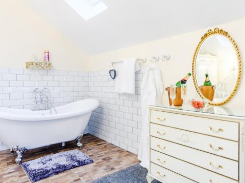 a white bathroom with a tub and a mirror at Hayloft- Uk31532 in Goxhill