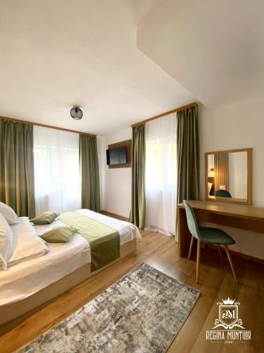 a hotel room with a bed and a desk at Regina Munților Spa&Confort in Moieciu de Sus