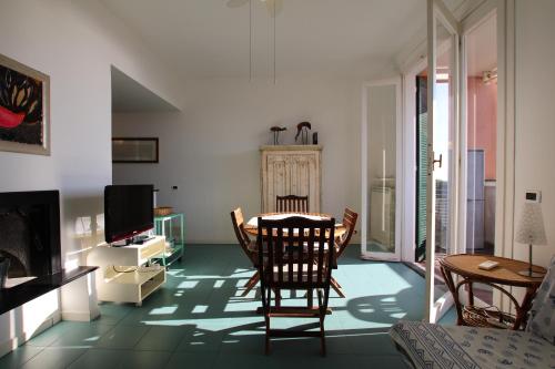 een woonkamer met een tafel en stoelen en een televisie bij Raffy's HOME in Arenzano
