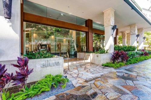 uma entrada para um edifício com flores em frente em Allure Waikiki #803 condo em Honolulu