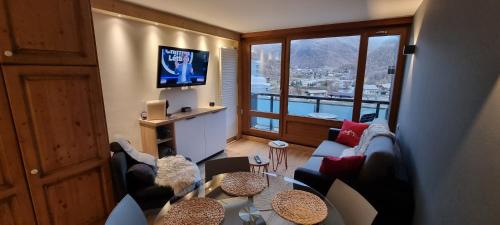 a living room with a couch and a tv at Le 1888 Val d'Isère in La Daille