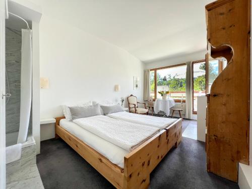 a bedroom with a wooden bed and a table at Casa Las Caglias in Flims