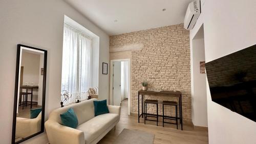 a living room with a couch and a brick wall at Mata Mua Suites in Seville