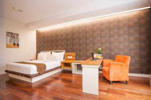 a bedroom with a bed and a desk and a chair at Life Hotel Sudirman Surabaya in Surabaya