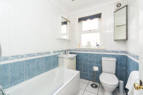 a bathroom with a tub and a toilet and a sink at Edridge Lodge Photo ID & Deposit Required in Croydon