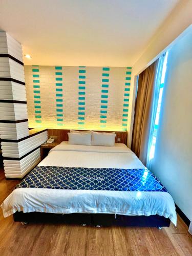 a bedroom with a bed with blue and white sheets at New World Express Motel in Bintulu
