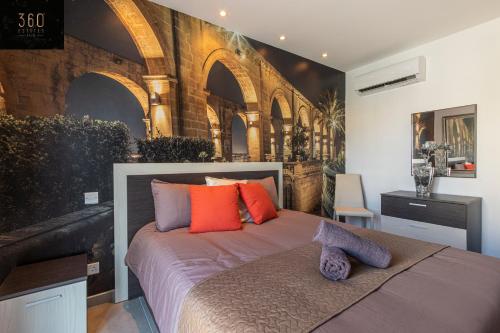 a bedroom with a bed with orange and purple pillows at High-End central APT with comfy BED & Super WIFI by 360 Estates in San Ġwann