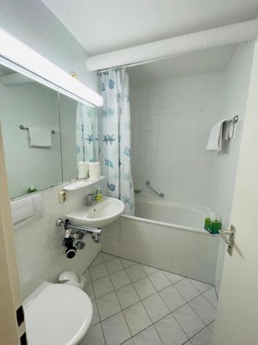 a bathroom with a toilet and a sink and a tub at Sunrise Studio für 2-3 Personen in Munich