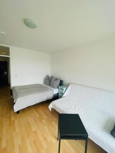 uma sala de estar com duas camas e uma mesa em Sunrise Studio für 2-3 Personen em Munique