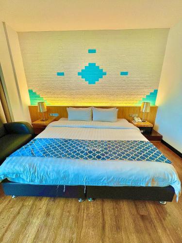 a bedroom with a large bed with a blue comforter at New World Express Motel in Bintulu
