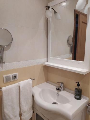 a bathroom with a sink and a mirror and towels at Adosado de María - Para 4 pax en Posada de Llanes in Llanes