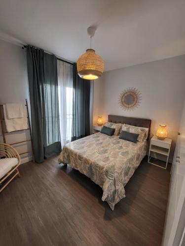 - une chambre avec un lit et un lustre dans l'établissement Alazán Jerez IV-Parking gratis-Wifi-Netflix, à Jerez de la Frontera