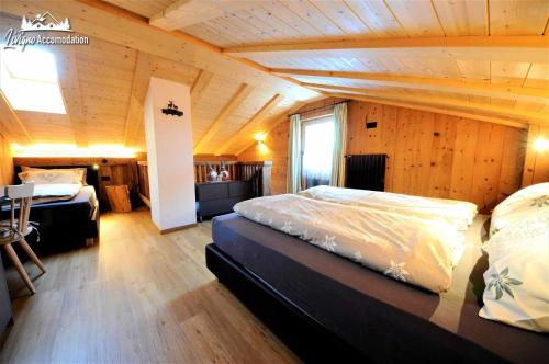 una camera con 2 letti e un soffitto in legno di Mountain Chalet Scoiattolo a Livigno