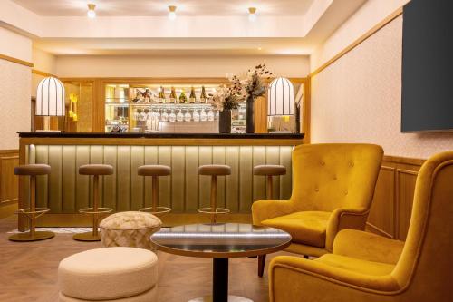 a bar with a yellow chair and a table at Best Western Plus Casablanca City Center in Casablanca
