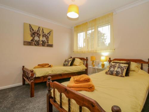 a bedroom with two beds and a window at 12 Parkers Hill in Thame
