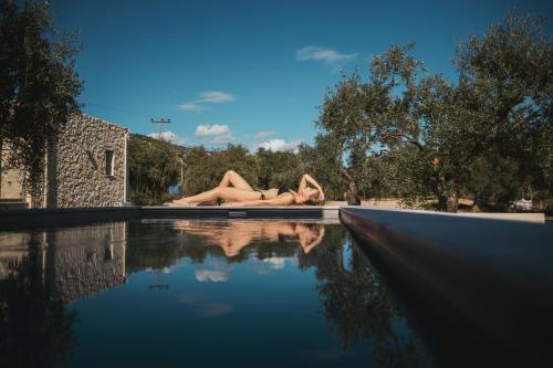 une femme se posant au bord d'une piscine dans l'établissement Magnolia Villas Thassos, à Potos