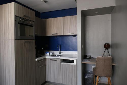 a kitchen with wooden cabinets and a sink and a chair at Le 22 Appart'Hotel in Casablanca