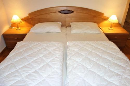 a large white bed with two lamps on two night stands at Magrappé M 231 - SKI LIFT apartment 6 pers in Veysonnaz