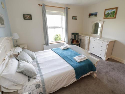 a bedroom with a bed and a dresser and a window at Teach Teolai in Carraroe