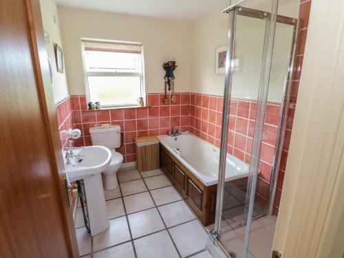 ein Badezimmer mit einer Badewanne, einem WC und einem Waschbecken in der Unterkunft Teach Teolai in Carraroe