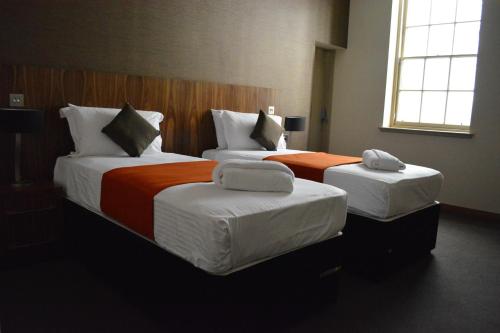 two beds in a hotel room with two bedsitures at The Inn Place in Edinburgh