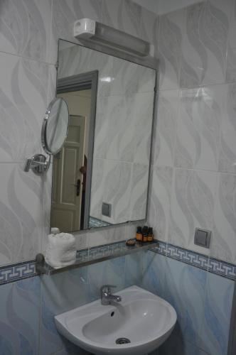 ein Bad mit einem Waschbecken und einem Spiegel in der Unterkunft EAST WEST HOTEL in Casablanca