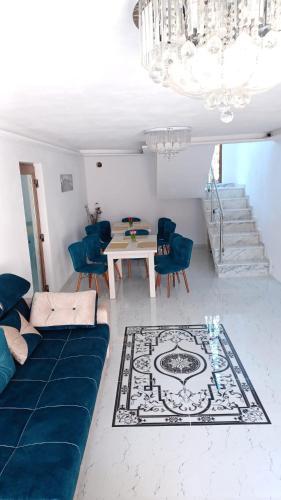 a living room with a table and blue chairs at Maria's Dream House in Zărneşti