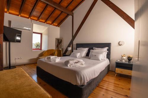 Quinta da Corredoura, Hotel Rural في غيمارايش: غرفة نوم بسرير كبير عليها منشفتين