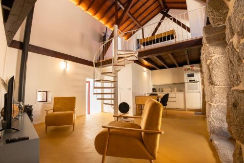 a living room with a spiral staircase in a loft at Quinta da Corredoura, Hotel Rural in Guimarães