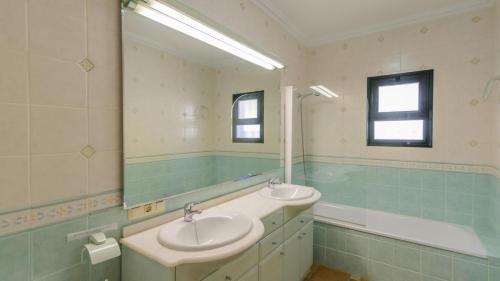 a bathroom with two sinks and a tub and a mirror at Villa el Pedregal Frigiliana by Ruralidays in Frigiliana