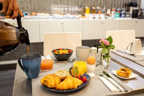 uma mesa com um prato de comida numa mesa em Hotel Glasgow Monceau by Patrick Hayat em Paris