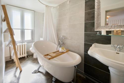 a bathroom with a sink and a toilet and a mirror at The Originals Boutique, Hôtel La Colonne de Bronze, Saint-Valéry-sur-Somme (Inter-Hotel) in Saint-Valéry-sur-Somme