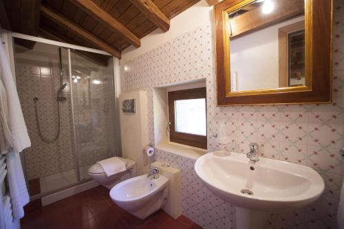 a bathroom with a sink and a toilet and a mirror at Albergo Diffuso La Piana dei Mulini in Colledanchise