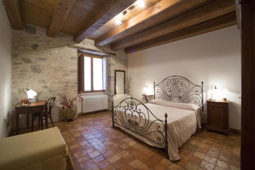 a bedroom with a bed and a table and a window at Albergo Diffuso La Piana dei Mulini in Colledanchise