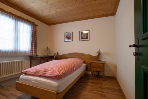 a small bedroom with a bed and a window at Hotel Bären in Gsteig