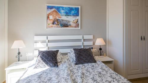 ein Schlafzimmer mit einem weißen Bett mit zwei Kissen in der Unterkunft Marina Real 414 in Manilva