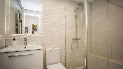 ein Bad mit einer Dusche, einem WC und einem Waschbecken in der Unterkunft Marina Real 414 in Manilva