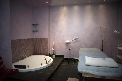 a bathroom with a tub and a bed in it at Residence Hotel Torino Uno in Turin