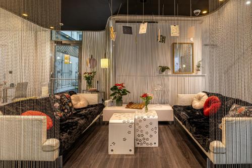 - un salon avec deux canapés et deux tables dans l'établissement Hotel Glasgow Monceau by Patrick Hayat, à Paris