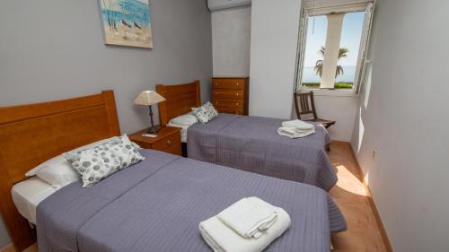 ein Hotelzimmer mit zwei Betten und einem Fenster in der Unterkunft Marina de Casares 25 10 in Casares