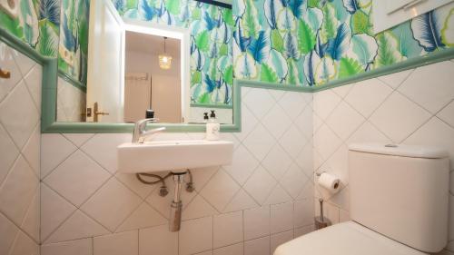ein Badezimmer mit Waschbecken, Toilette und Spiegel in der Unterkunft Marina de Casares 25 10 in Casares