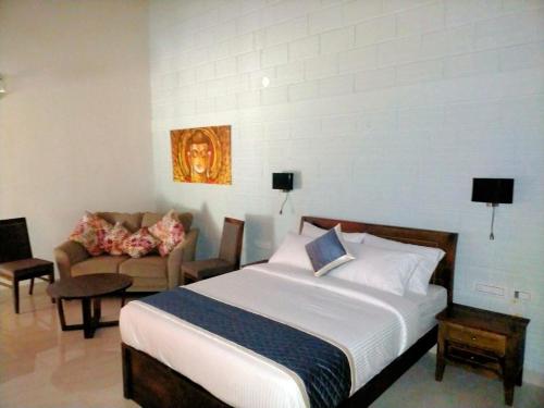 a bedroom with a large bed and a couch at Coffeeberry Hills Chikamagalur in Chikmagalūr