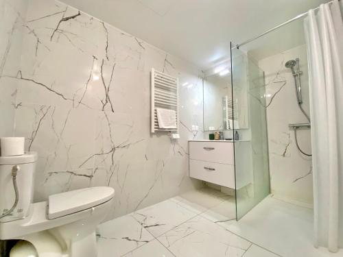 een witte badkamer met een toilet en een douche bij "Cap Riviera" Proche Gare et Centre in Menton