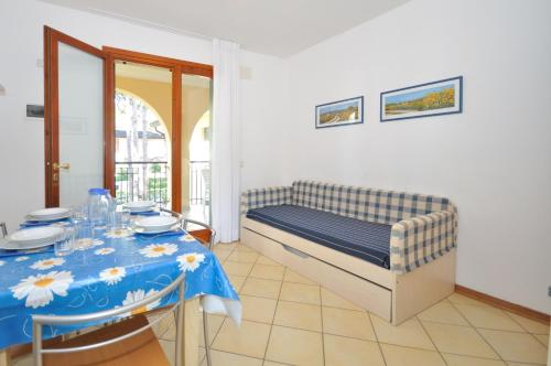 Villaggio Orchidea في بيبيوني: غرفة نوم مع سرير وطاولة مع قطعة قماش من الطاولة الزرقاء