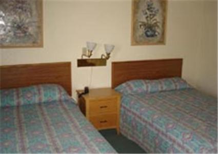 Habitación de hotel con 2 camas y mesita de noche en Miles Motel en Mesa