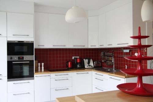 une cuisine avec des placards blancs et un tabouret rouge dans l'établissement Superbe maison avec jardin magnifique!, à Schiltigheim