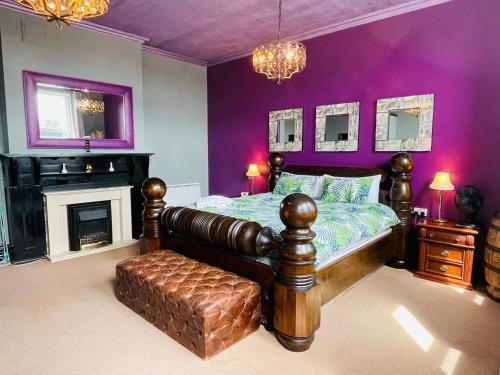 ein lila Schlafzimmer mit einem Bett und einem Kamin in der Unterkunft PHOENIX Boutique Apartments in Goole