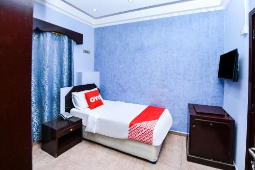 OYO 137 Marina Hotel في مسقط: غرفة فندق بسرير وتلفزيون
