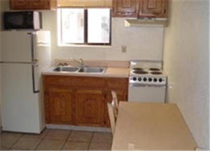 a kitchen with a white refrigerator and a sink at Miles Motel in Mesa