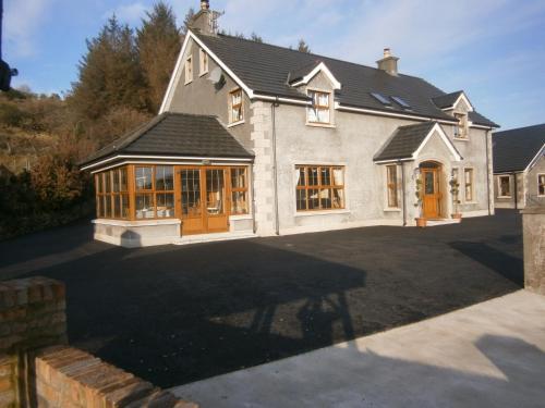 a large white house with a large driveway at Glenn Eireann House in Cushendun